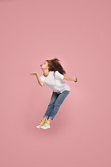 Image showing Freedom in moving. Pretty young woman jumping against pink background