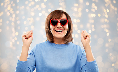 Image showing smiling senior woman in heart-shaped sunglasses