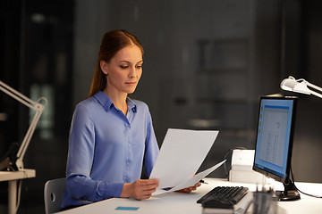 Image showing businesswoman with papers working at night office