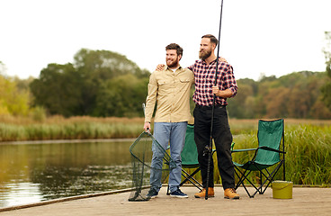 Image showing friends with fishing rods and net at lake or river
