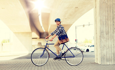 Image showing young hipster man with bag riding fixed gear bike