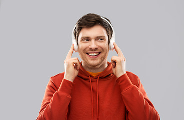 Image showing happy young man in headphones and red hoodie