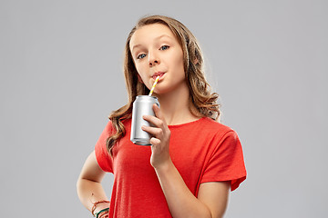 Image showing girl drinking soda from can through paper straw