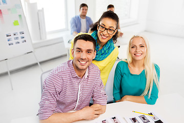 Image showing creative team with photos at model agency office