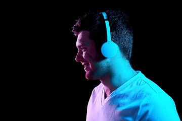 Image showing man in headphones over neon lights of night club