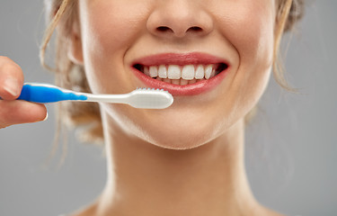 Image showing close up of woman with toothbrush cleaning teeth