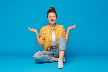 Image showing smiling red haired teenage girl shrugging