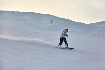 Image showing Female snowboarder in sun flare