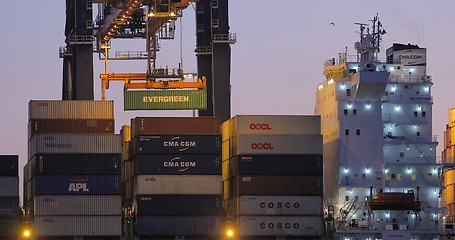 Image showing Loading containers on a ship at dawn