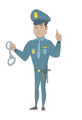Image showing Young hispanic policeman holding handcuffs.