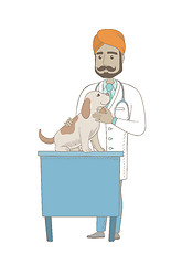 Image showing Young indian veterinarian examining dog.