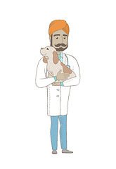 Image showing Young indian veterinarian with dog in hands.