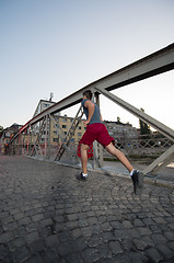 Image showing man jogging across the bridge at sunny morning