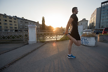 Image showing athlete man warming up and stretching