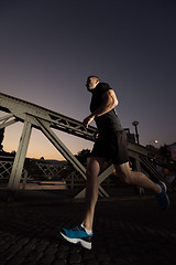 Image showing man jogging across the bridge in the city