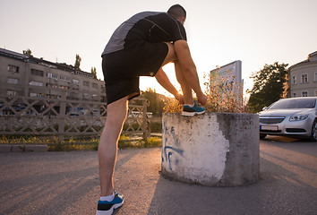 Image showing man tying running shoes laces