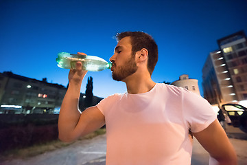 Image showing man drinking water after running session