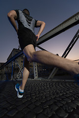 Image showing man jogging across the bridge in the city