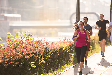 Image showing group of young people jogging in the city