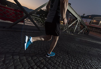 Image showing man jogging across the bridge in the city