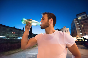 Image showing man drinking water after running session