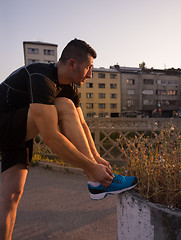 Image showing man tying running shoes laces