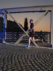 Image showing man jogging across the bridge in the city