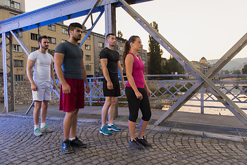 Image showing group of young people jogging across the bridge