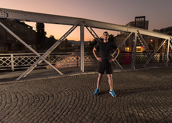 Image showing man jogging across the bridge in the city