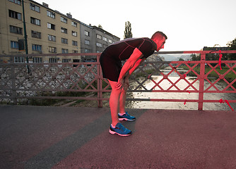 Image showing man jogging across the bridge at sunny morning