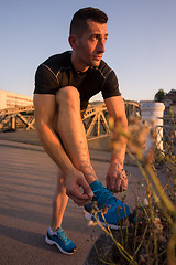 Image showing man tying running shoes laces