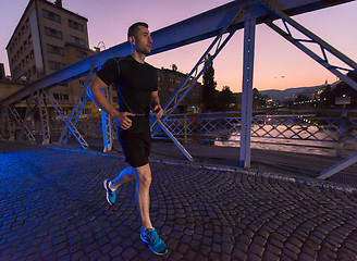 Image showing man jogging across the bridge in the city