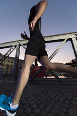 Image showing man jogging across the bridge in the city