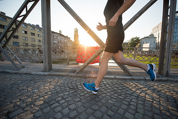 Image showing man jogging across the bridge at sunny morning