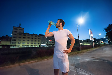 Image showing man drinking water after running session