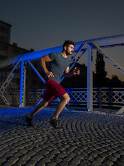 Image showing man jogging across the bridge in the city