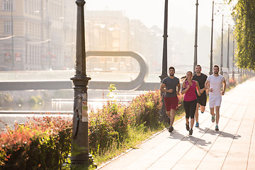 Image showing group of young people jogging in the city