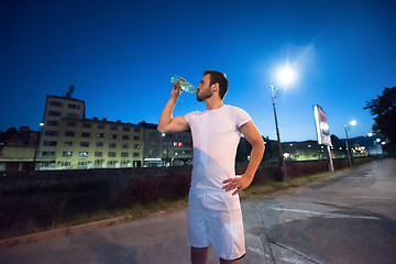 Image showing man drinking water after running session