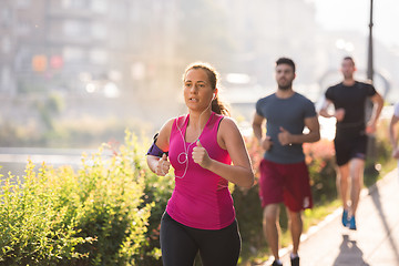 Image showing group of young people jogging in the city