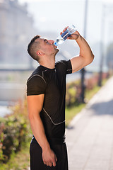 Image showing man drinking water from a bottle after jogging