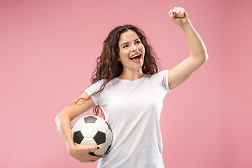 Image showing Fan sport woman player holding soccer ball isolated on pink background