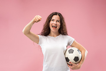 Image showing Fan sport woman player holding soccer ball isolated on pink background