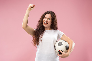 Image showing Fan sport woman player holding soccer ball isolated on pink background