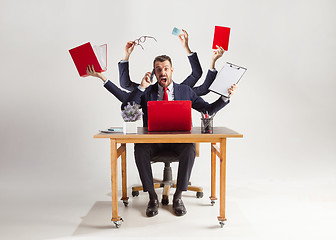 Image showing businessman with many hands in elegant suit working with paper, document, contract, folder, business plan.