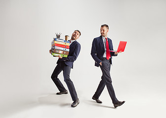 Image showing Young businessman in a suit juggling with office supplies in his office, isolated on white background