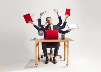 Image showing businessman with many hands in elegant suit working with paper, document, contract, folder, business plan.