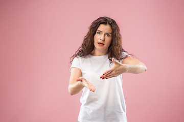 Image showing Beautiful female half-length portrait isolated on pink studio backgroud. The young emotional surprised woman