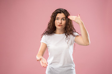 Image showing Beautiful female half-length portrait isolated on pink studio backgroud. The young emotional surprised woman