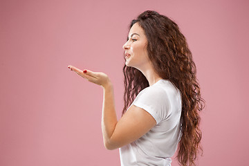 Image showing The happy business woman standing and smiling against pink background.