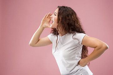 Image showing Isolated on pink young casual woman shouting at studio